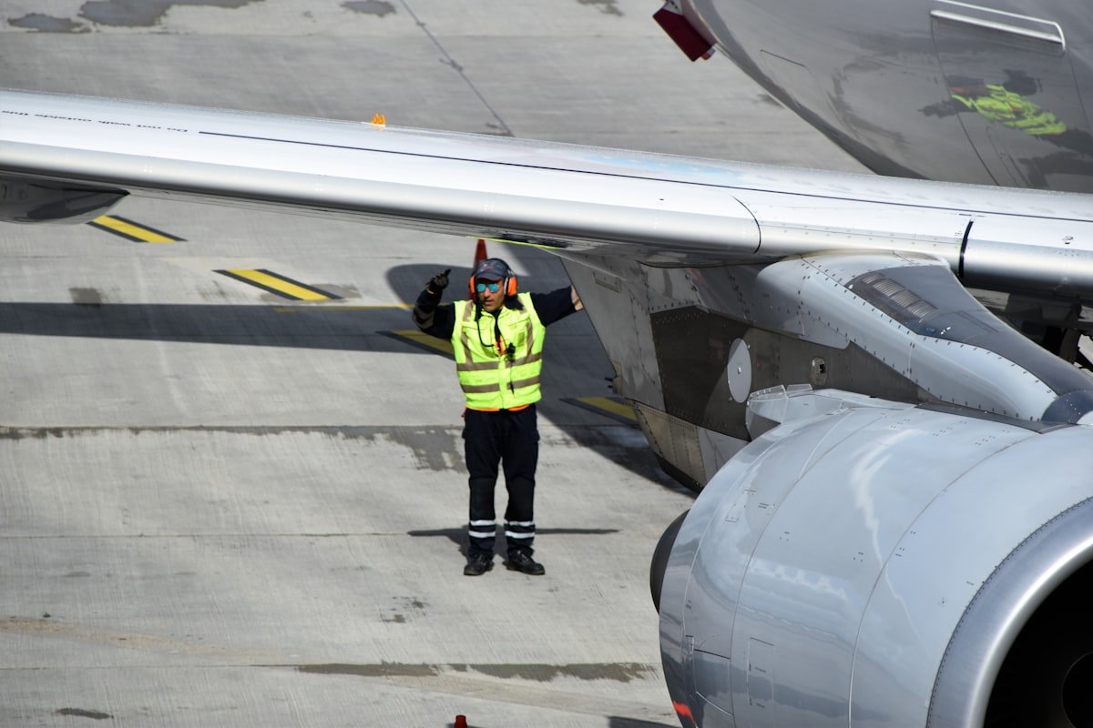 Airport ground staff marshalling an aircraft on the tarmac